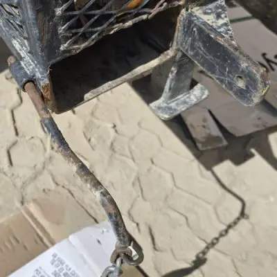Cheap rod-style retaining pin failure on forklift jib fork pocket showing bent pin and unsafe retention design.