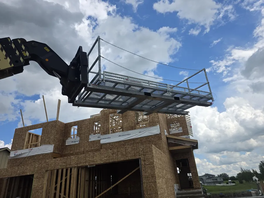 ManBaskets work platform raised by a telehandler at a residential construction site